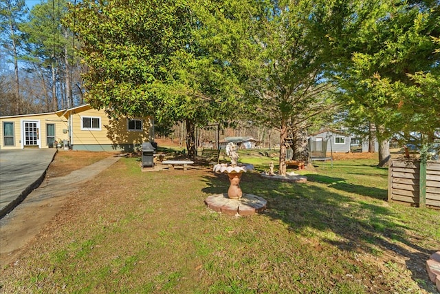 view of yard featuring a trampoline and fence