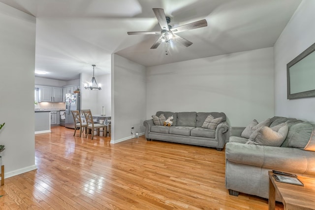 1521 Ashton Woods Way, Dalton, GA 30720 - living room with ceiling fan with notable chandelier, baseboards, and light wood finished floors