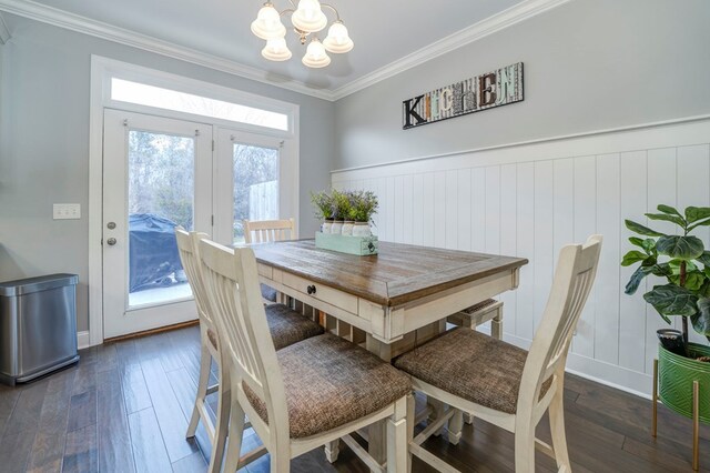 dining room with ornamental molding, a chandelier, and dark hardwood / wood-style flooring