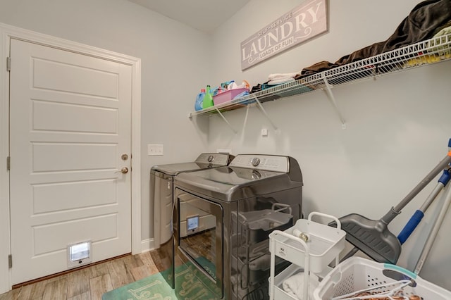 clothes washing area featuring independent washer and dryer and light hardwood / wood-style flooring