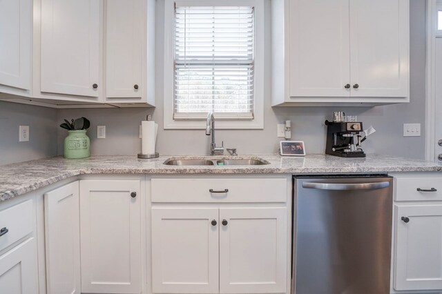 kitchen with dishwasher, sink, white cabinets, and light stone counters