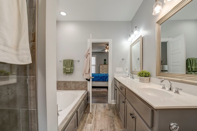 bathroom featuring hardwood / wood-style flooring, vanity, ceiling fan, and a bathtub