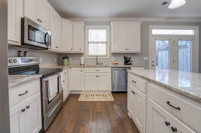 kitchen featuring sink, crown molding, appliances with stainless steel finishes, light stone countertops, and white cabinets