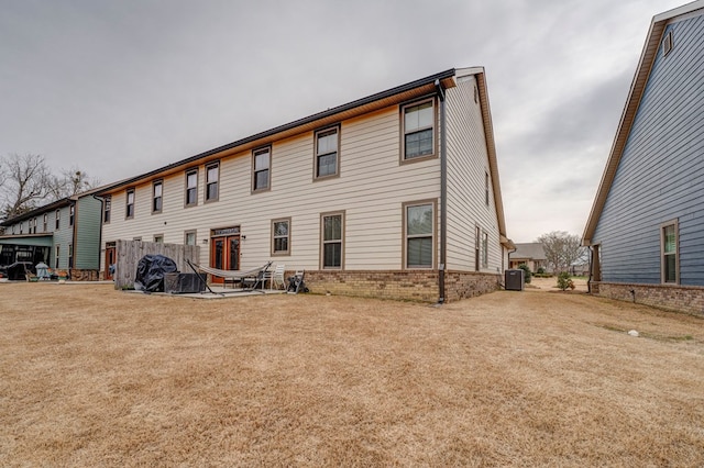 back of property with cooling unit and a yard