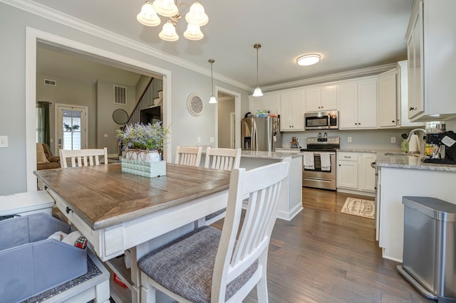 dining space featuring an inviting chandelier, ornamental molding, dark hardwood / wood-style floors, and sink