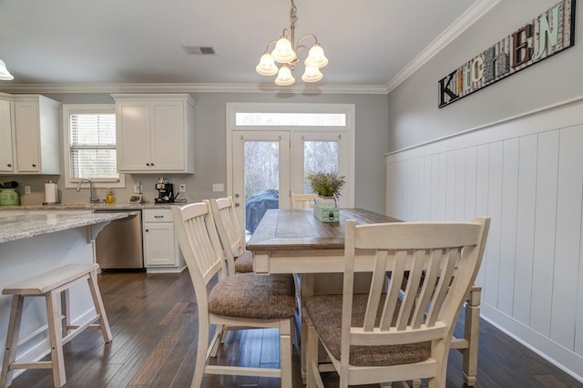 dining space featuring ornamental molding, dark wood-type flooring, a notable chandelier, and french doors