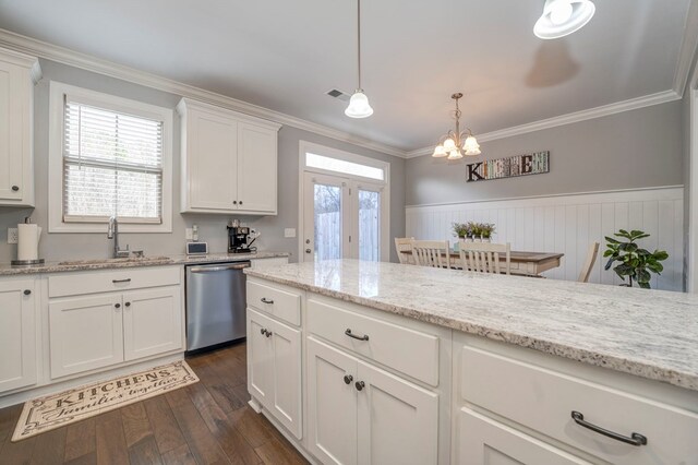 kitchen featuring white cabinetry, light stone counters, stainless steel dishwasher, ornamental molding, and pendant lighting