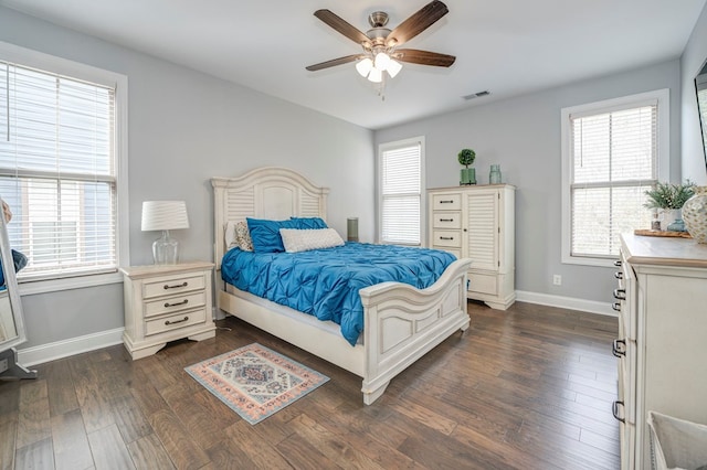 bedroom featuring multiple windows, dark wood-type flooring, and ceiling fan