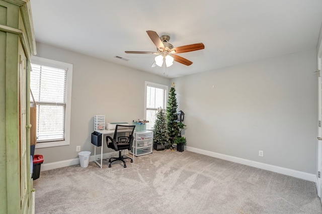 carpeted office space featuring ceiling fan