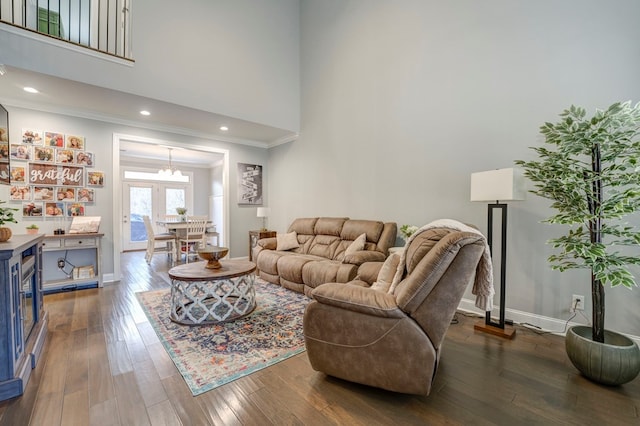 living room featuring a towering ceiling, ornamental molding, and dark hardwood / wood-style flooring