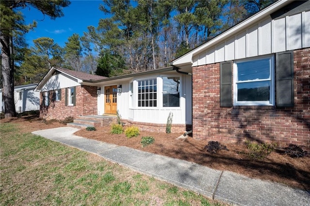 single story home featuring board and batten siding and brick siding