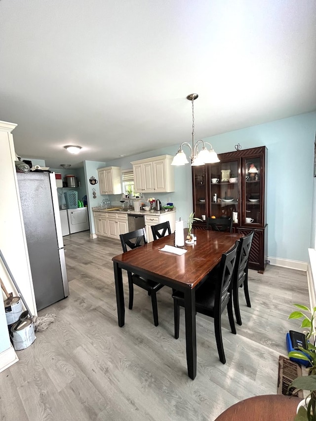 609 Charles St, Dalton, GA 30720 - dining space with independent washer and dryer, light wood finished floors, and a chandelier