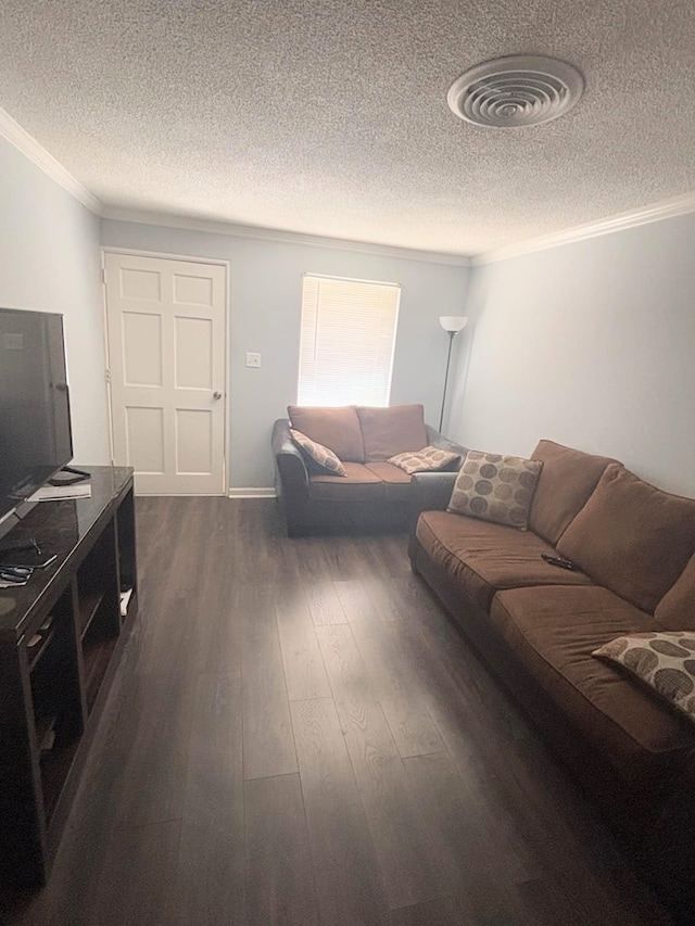 living area featuring dark wood-style floors, visible vents, a textured ceiling, and ornamental molding