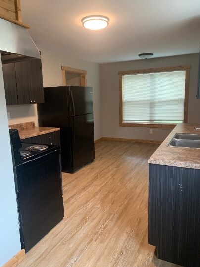 kitchen featuring sink, black appliances, and light hardwood / wood-style floors