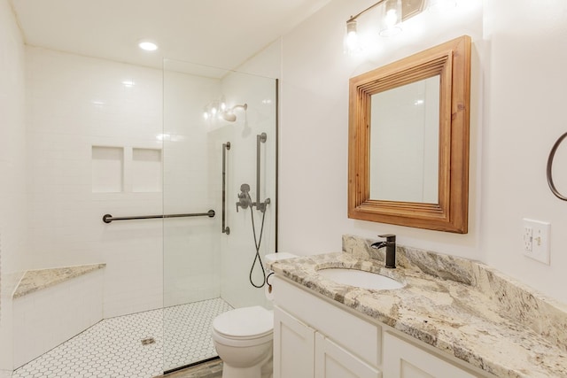 full bath with toilet, vanity, and a tile shower