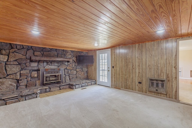 unfurnished living room with heating unit, wood walls, wooden ceiling, and carpet