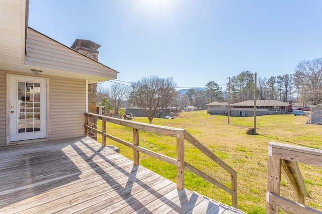 wooden terrace featuring a lawn