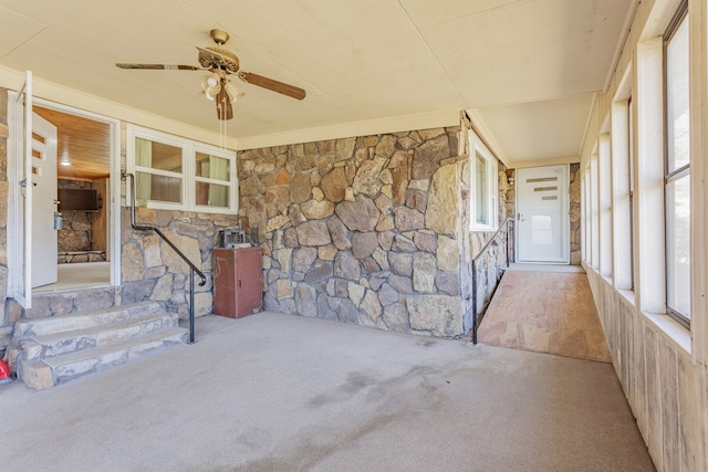 unfurnished sunroom featuring ceiling fan