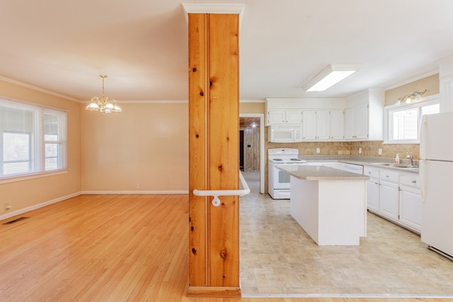 kitchen featuring white appliances, visible vents, a kitchen island, white cabinetry, and crown molding