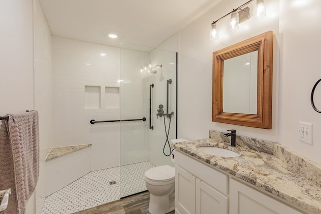 full bath featuring toilet, walk in shower, wood finished floors, and vanity