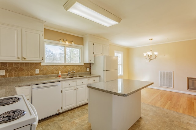 kitchen with visible vents, ornamental molding, a sink, white appliances, and decorative backsplash