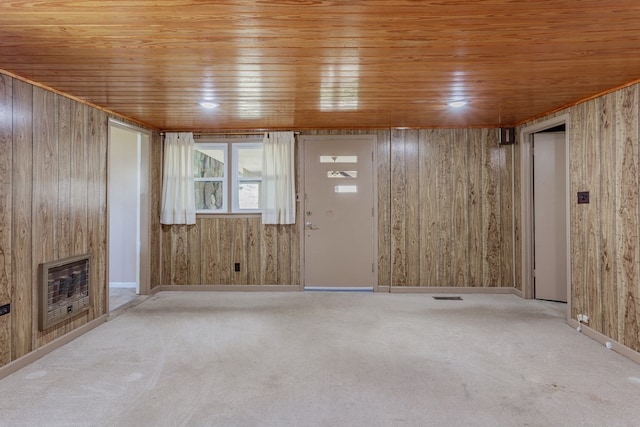 unfurnished living room featuring heating unit and wood walls