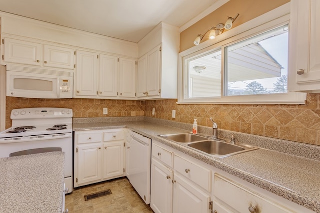 kitchen with visible vents, light countertops, decorative backsplash, white appliances, and a sink