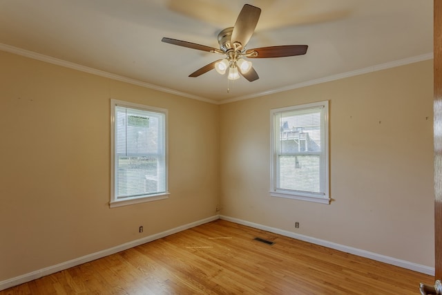 spare room featuring a wealth of natural light, visible vents, light wood finished floors, and baseboards