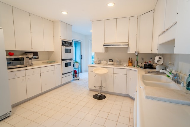 kitchen with white cabinetry, sink, and white appliances