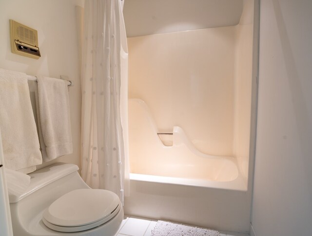 bathroom featuring tile patterned flooring, shower / tub combo, and toilet