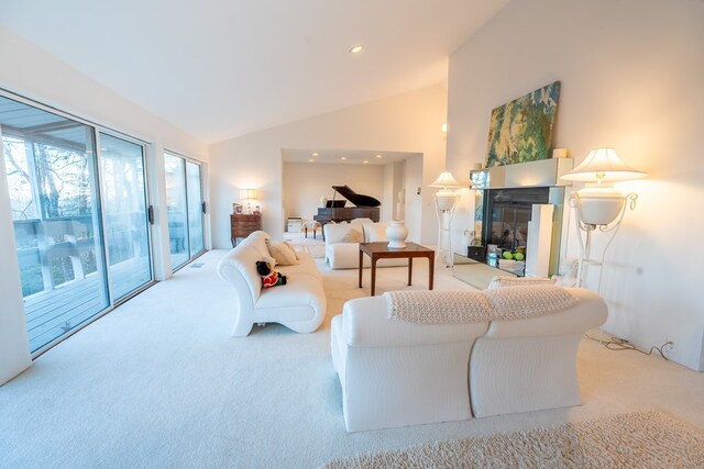 living room featuring light carpet and high vaulted ceiling