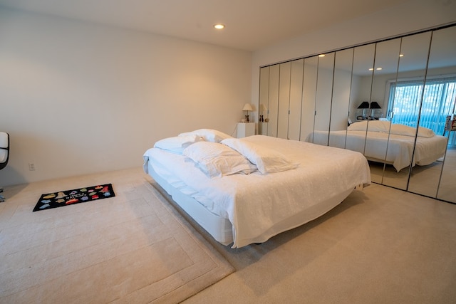 bedroom with light colored carpet and a closet