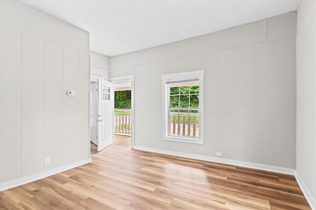 spare room featuring light wood finished floors and baseboards