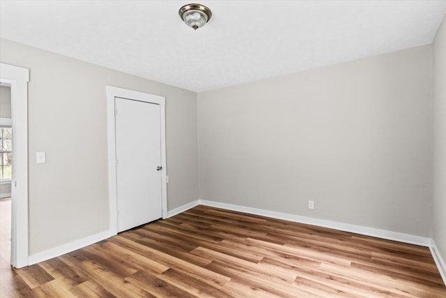 empty room with baseboards and wood finished floors