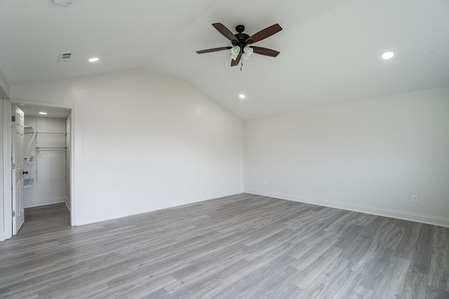 unfurnished room featuring lofted ceiling, a ceiling fan, baseboards, visible vents, and light wood-style floors