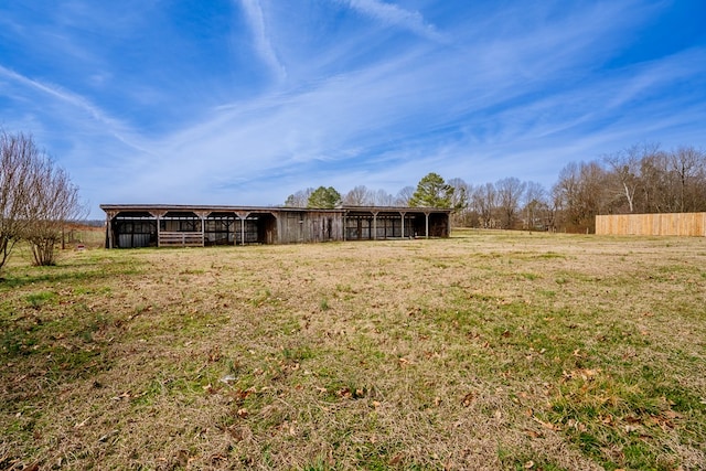 exterior space featuring an outbuilding, a rural view, a yard, and an outdoor structure