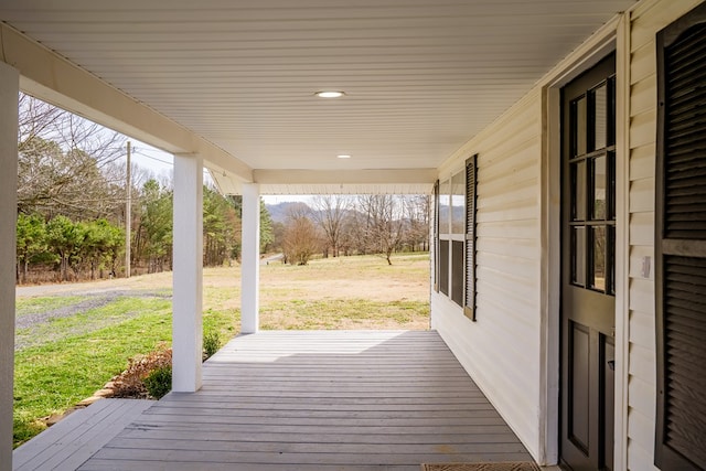 wooden deck with a porch and a yard