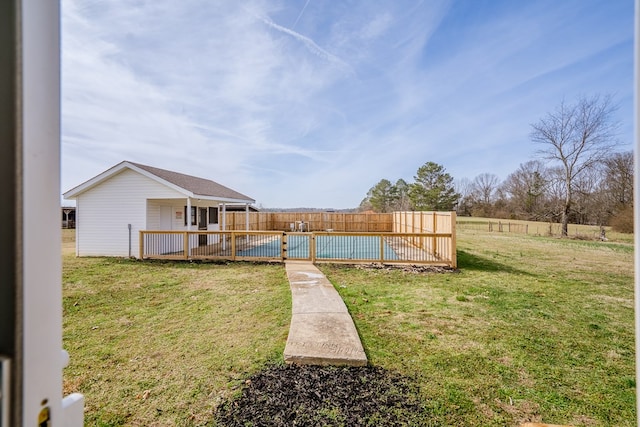 view of yard with fence and a swimming pool