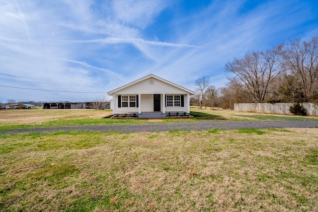 bungalow-style home with fence and a front yard