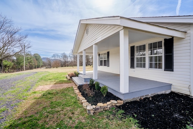 view of property exterior with a porch and a lawn