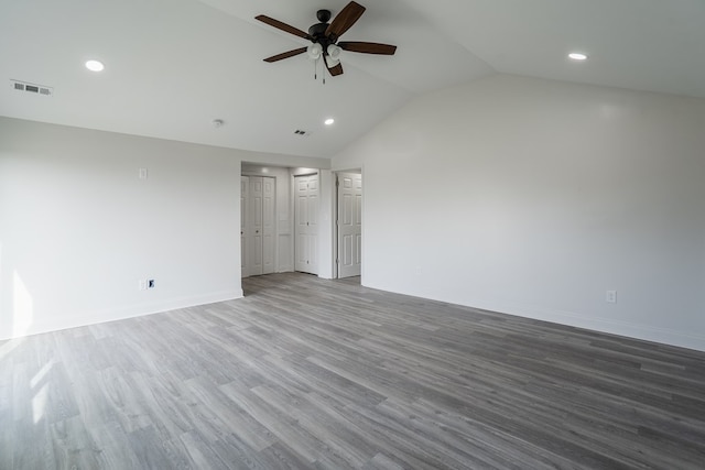 spare room featuring visible vents, vaulted ceiling, baseboards, and wood finished floors