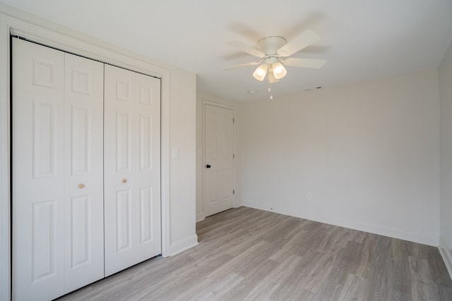 unfurnished bedroom featuring light wood finished floors, a closet, visible vents, ceiling fan, and baseboards