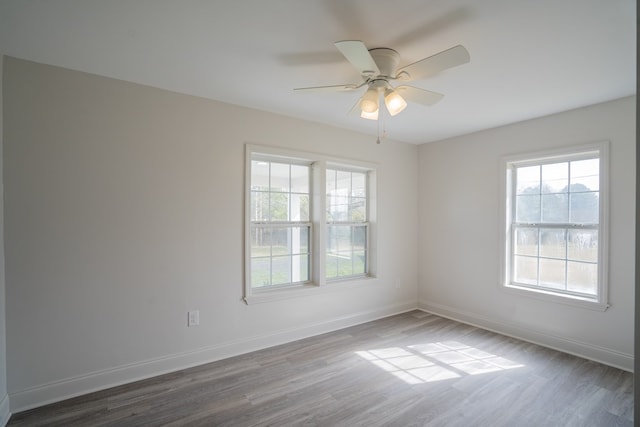 unfurnished room featuring wood finished floors, a ceiling fan, and baseboards