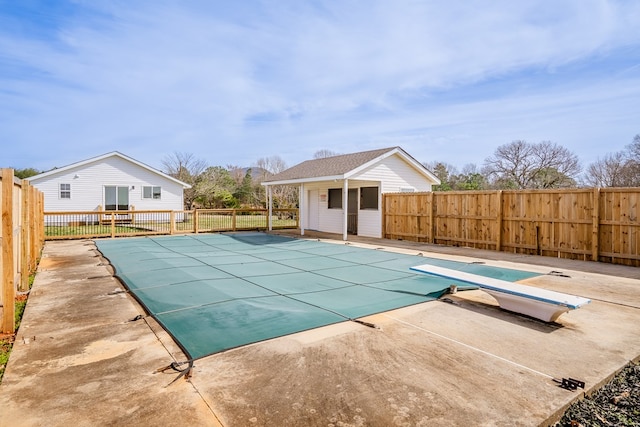 view of swimming pool featuring a fenced in pool, an outbuilding, a patio, and fence