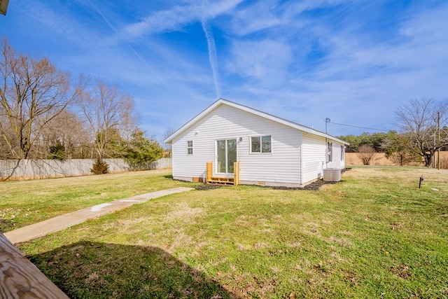 rear view of house featuring entry steps, crawl space, central AC, and a lawn