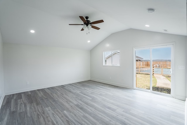 interior space featuring lofted ceiling, recessed lighting, ceiling fan, wood finished floors, and baseboards