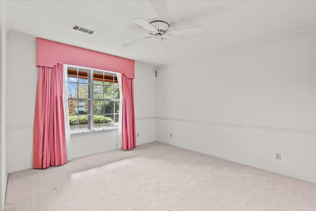 carpeted empty room featuring ceiling fan, ornamental molding, and a textured ceiling