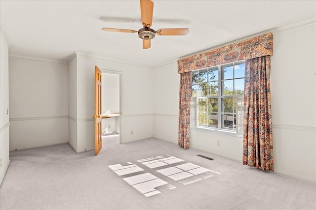 empty room with light carpet, crown molding, a textured ceiling, and ceiling fan