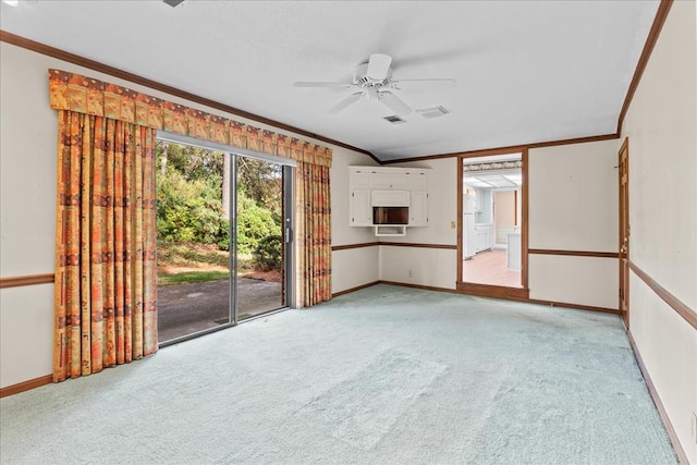 unfurnished living room with ceiling fan, ornamental molding, and light carpet