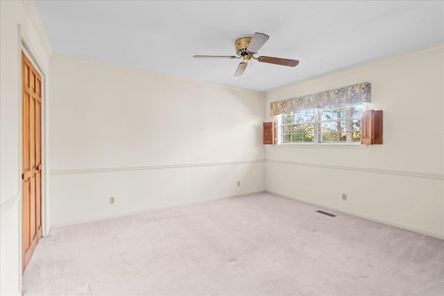 unfurnished room featuring crown molding, light colored carpet, and ceiling fan